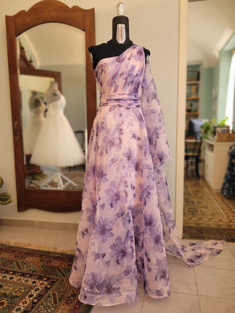 Abito monospalla viola a fiori con corpino drappeggiato in voile, cintura drappeggiata e ala.