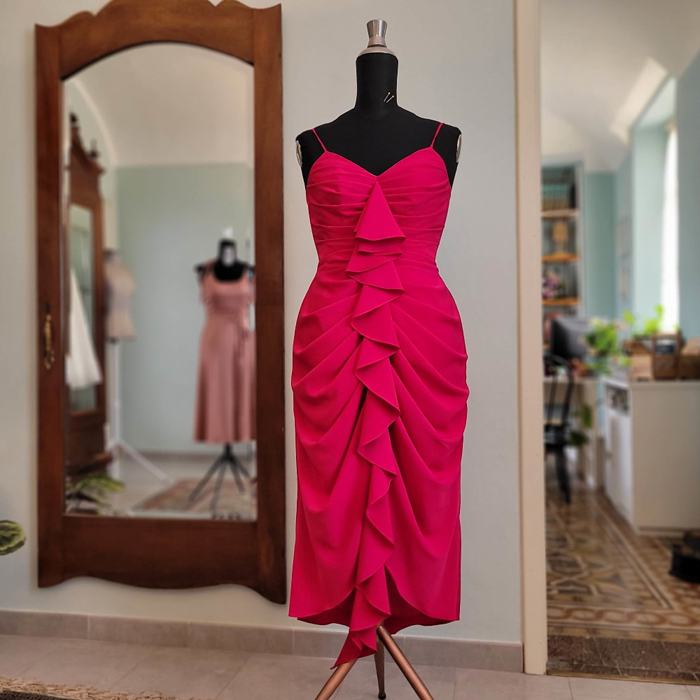 Abito rosso magenta/fucsia longuette in cady drappeggiato sul davanti con rouche e spalline sottili.