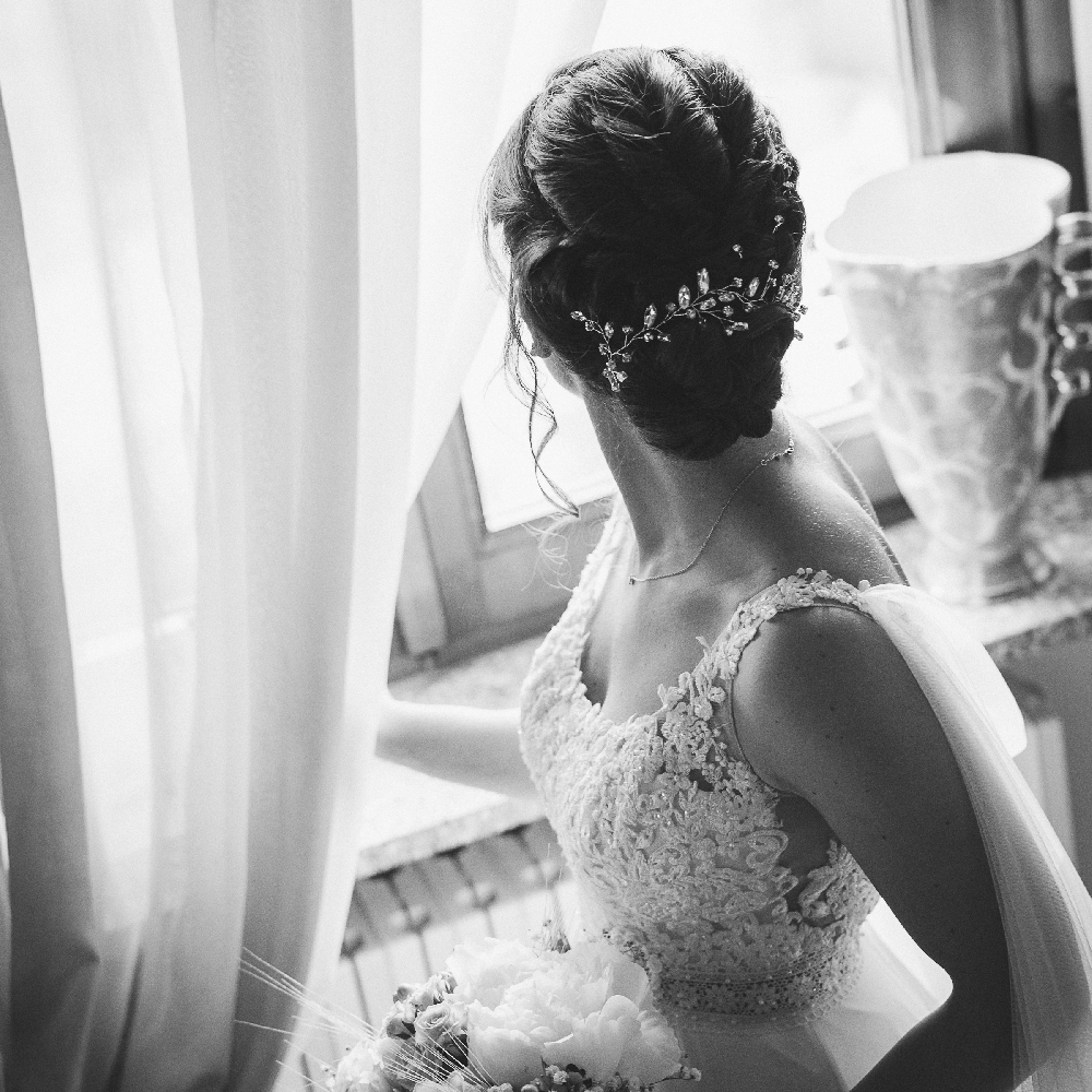 Abito da sposa in pizzo con mantella di tulle.